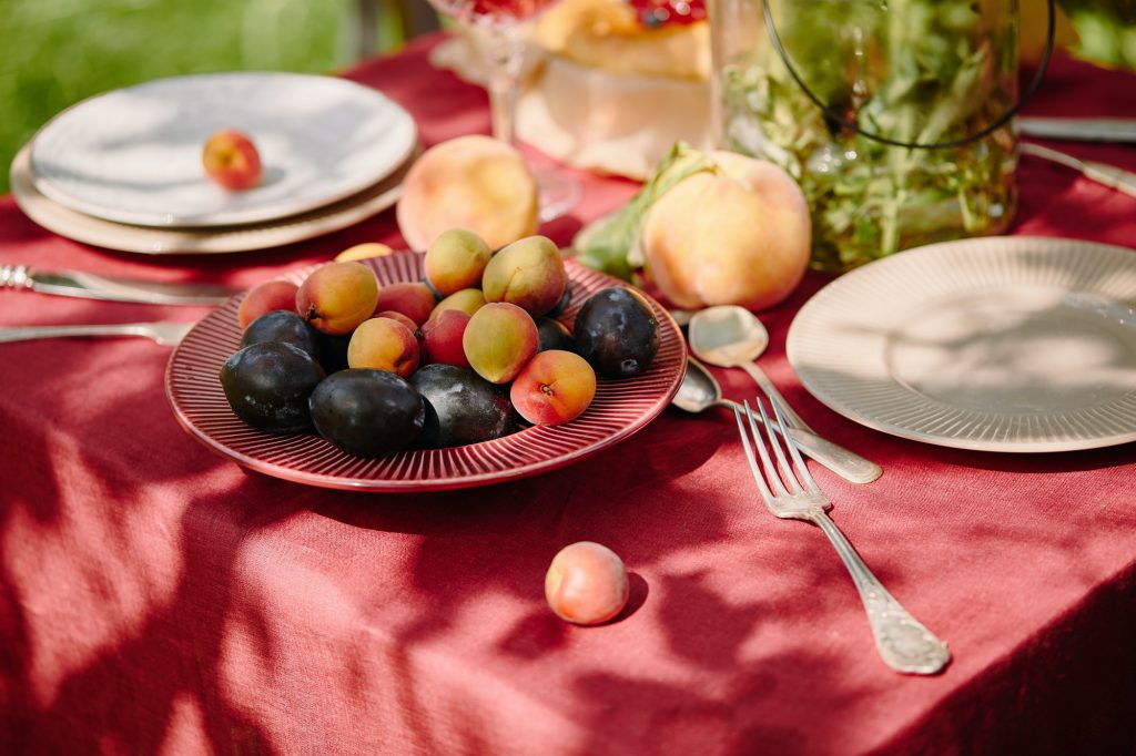 fruits, forks and plates on table in garden